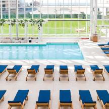 una piscina con sedie a sdraio blu e una piscina