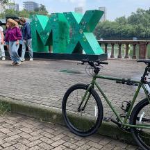 a bike parked next to a bridge with a sign