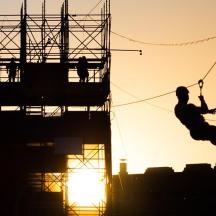 a man is jumping in the air on a zip line