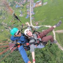 two people are hanging from a parachute