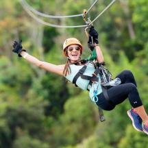 a woman flying through the air on a parachute