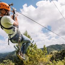 a man on a zip line in the mountains
