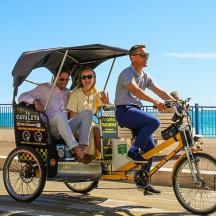 a group of people riding in a bike pulled cart