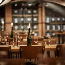 un restaurant amb taules amb ampolles i copes de vi