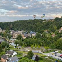 two hot air balloons are flying over a town
