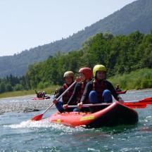 three people in a raft on a river