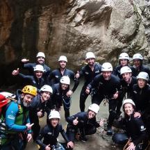 a group of people posing for a picture in a cave