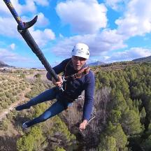 a man flying through the air on a zip line
