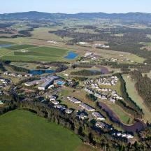 an aerial view of a park with houses and a lake
