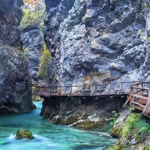 a bridge over a river in a rocky canyon