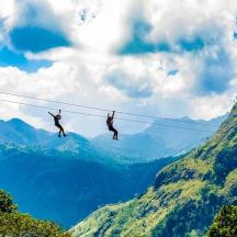 two people on a zip line in the mountains