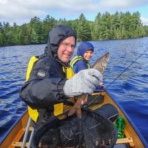 a man and a child in a boat with a large fish