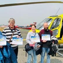 a group of people standing in front of a helicopter