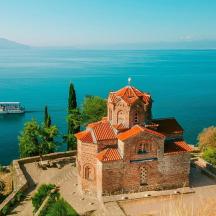 an old building on the edge of the water with a boat