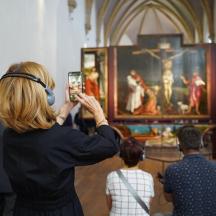 žena fotografující obraz v muzeu