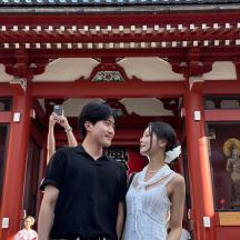 a man and a woman standing in front of a temple