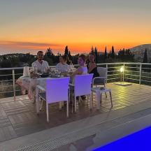 a group of people sitting around a table on a balcony