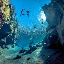 a group of people swimming in an underwater cave