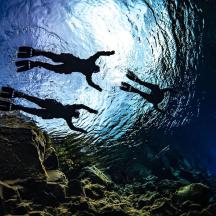 der Schatten eines Mannes, der im Wasser schwimmt