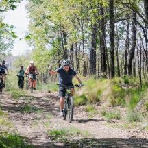 a group of people riding bikes down a dirt trail