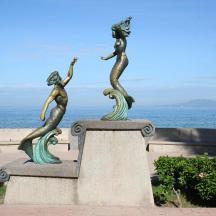 kip treh morskih deklic na steni blizu oceana