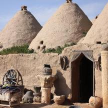 a stone building with two straw hats and a wheel