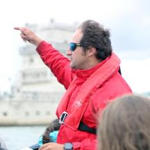 a man in a red jacket pointing at a building