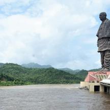 a statue of a man standing on a bridge over a river