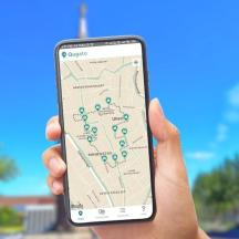 地図が映った携帯電話を掲げている人