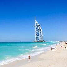 a group of people on a beach with a building