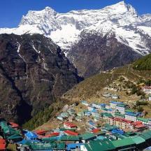 a group of buildings in front of a mountain