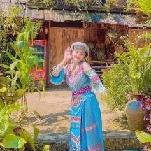 a little girl in a dress standing in a garden
