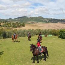 a group of people riding horses in a field