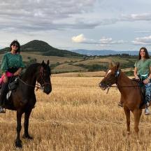 due donne a cavallo in un campo