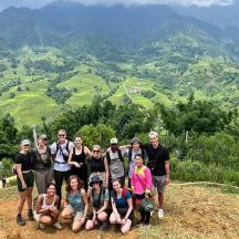 a group of people posing for a picture on a mountain