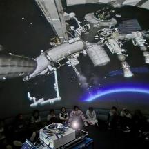 un gruppo di persone in piedi davanti a una stazione spaziale