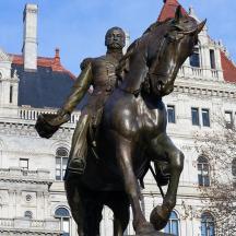 eine Statue eines Mannes auf einem Pferd vor einem Gebäude