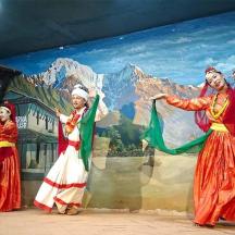 a group of women dancing in front of a mural