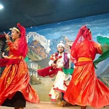 tres dones interpretant una dansa folklòrica davant d'un mural