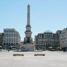 a statue in the middle of a city with buildings