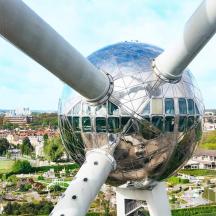 a large wind turbine with a city in the background