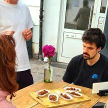 un home assegut a una taula amb un plat de donuts
