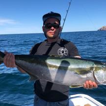 un uomo che tiene in mano un grosso pesce nell'acqua