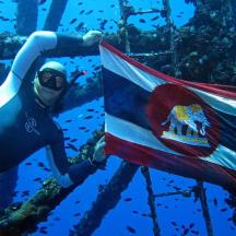 a diver is holding a flag in the ocean