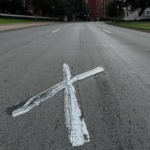 a white cross painted on the middle of a road