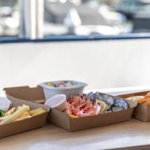a table topped with boxes of food and a drink