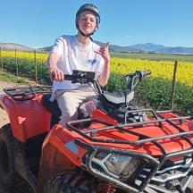 a man sitting on a atv in front of a field