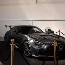 ein schwarzes Auto in einem Raum mit einem roten Band geparkt