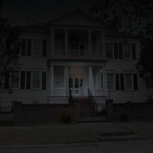 a white house with a porch at night