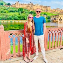 a man and a woman standing on a bridge in front of a castle